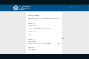 Screenshot of a form from U.S. Citizenship and Immigration Services with security questions and text fields for answers. Question 1 asks about a childhood teacher, and Question 2 about a first job.